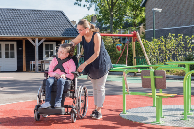 a disabled child in a wheelchair being cared for by a caregiver